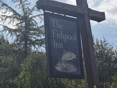 The sign of The Fishpool Inn with a fish illustration outside