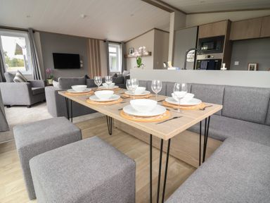 A dining room with a table and chairs at Cedar Lodge 2 Bedrooms with hot tub Delamere