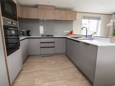 A kitchen with appliances and cabinets at Cedar Lodge 2 Bedrooms with hot tub Delamere