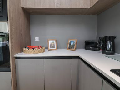 A kitchen with appliances and framed pictures at Cedar Lodge 2 Bedrooms with hot tub Delamere