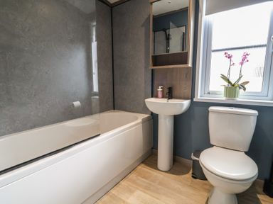 A bathroom with a bathtub, sink, and toilet at Cedar Lodge 2 Bedrooms with hot tub Delamere