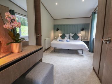 A bedroom with a bed and dresser at Cedar Lodge 2 Bedrooms with hot tub in Delamere