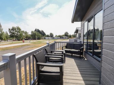 An outdoor area with seating on a deck at Cedar Lodge 2 Bedrooms with hot tub, Delamere