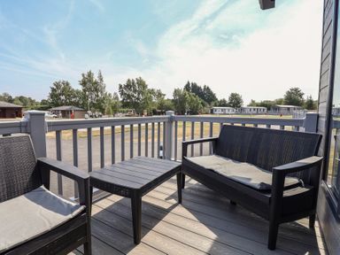 An outdoor seating area with furniture at Cedar Lodge 2 Bedrooms with hot tub in Delamere