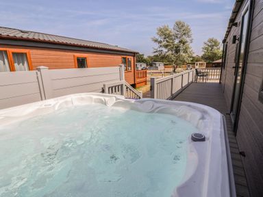 A hot tub on a deck area at Cedar Lodge 2 Bedrooms with hot tub in Delamere