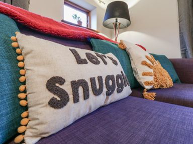 A living room with a couch and decorative pillows at The Pantiles in Banham