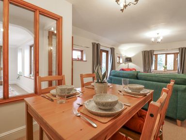 A dining room with a table set for dinner at The Pantiles in Banham