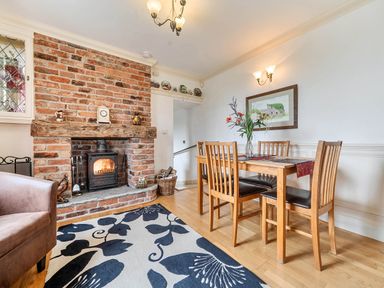 A dining room with a wooden table and chairs at Bank House Cottage in Glasson Dock
