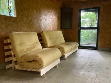 A seating area with two sofas and a window at The Tree House in the Woods Longhope