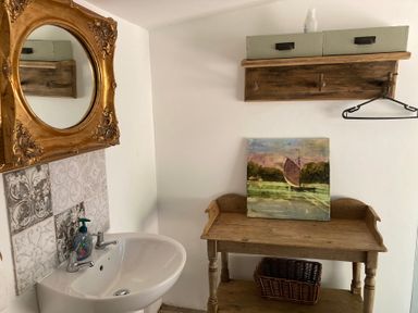 A bathroom with a sink and a wooden table at Cosy Shepherd’s Hut in Longhope