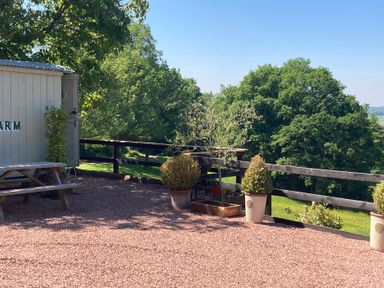 An outdoor area with a shed and a bench at Cosy Shepherd’s Hut in Longhope