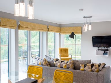 A living room with a sofa and armchair at Pinemarten Lodge Crianlarich