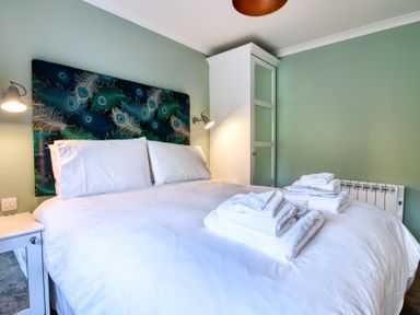 A bedroom with a bed and towels at Pinemarten Lodge in Crianlarich