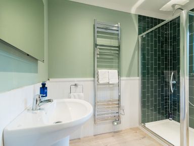 A bathroom with a sink and a shower at Pinemarten Lodge Crianlarich