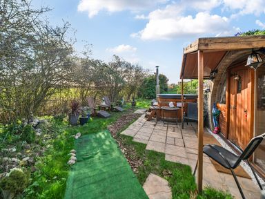 A garden with a hot tub and seating area at Cosy Escape in Minster On Sea