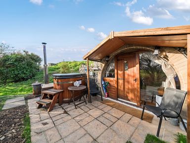 An outdoor area with a hot tub and seating at Cosy Escape in Minster On Sea