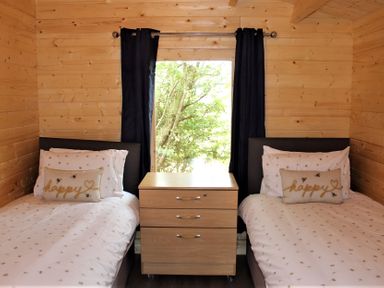 A bedroom with two beds and a nightstand at Cotswold Nights Away in Evesham