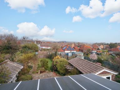 A view of houses and gardens with trees and fences at 15 Coombe Avenue