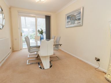 A dining room with a table and chairs at Tudor Rose in Weymouth