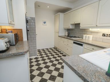 A kitchen with various appliances and cabinets at Tudor Rose in Weymouth