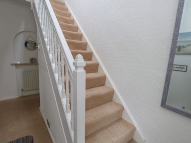 A staircase in a hallway at Tudor Rose in Weymouth