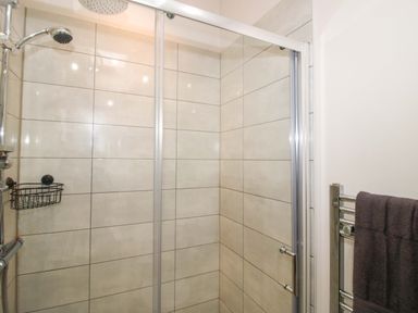 A shower area with tiles and a towel rail at 5 Hillview Lodges Cleobury Mortimer