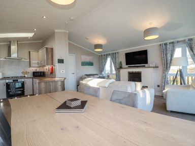 A living room with a kitchen area and dining table at Moorland View