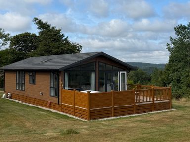 A lodge with a deck situated in a garden at Moorland View in Dobwalls