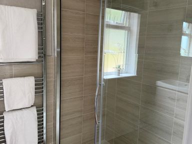 A bathroom with towels on a rack and a shower at Moorland View in Dobwalls