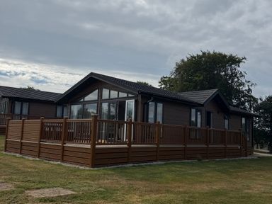 A house with a deck and multiple windows at Moorland View in Dobwalls