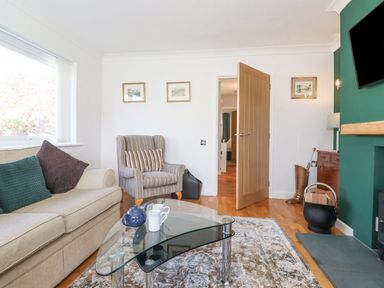 A living room with a sofa and armchair and decorative pictures at Wansfell View in Ambleside