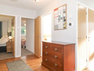 A hallway with a chest of drawers and wall board at Wansfell View in Ambleside