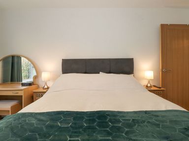 A bedroom with a bed and table at Wansfell View in Ambleside