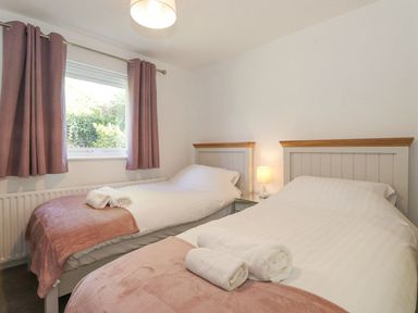 A bedroom with two beds and curtains at Wansfell View in Ambleside
