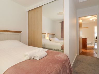 A bedroom with a bed and wardrobe at Wansfell View in Ambleside