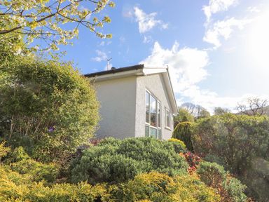 A house with windows and bushes at Wansfell View Ambleside