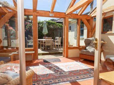 A conservatory with a table and chairs at Pillars in Barnstaple