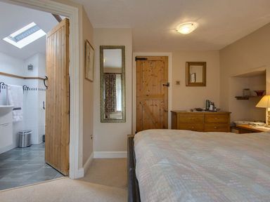 A bedroom with a bed and dressers at Pillars in Barnstaple
