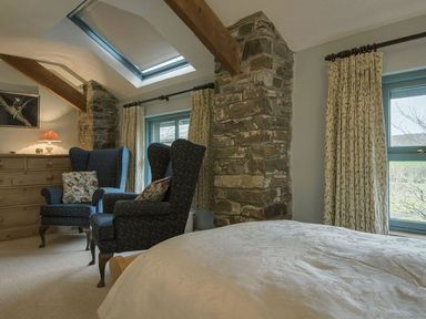 A bedroom with armchairs and a chest of drawers at Pillars in Barnstaple
