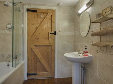 A bathroom with a bathtub and sink at Pillars in Barnstaple