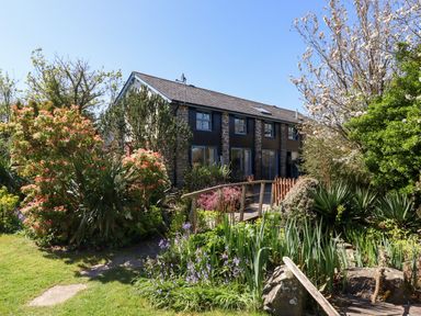 A house with a garden and bridge at Pillars in Barnstaple