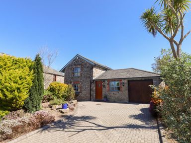 A house with a driveway and garden at Pillars Barnstaple