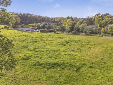 A field with trees and parked cars at Cedar Lodge 3 Bedrooms with hot tub Delamere