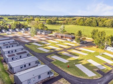 An outdoor view of caravans and parking spaces at Cedar Lodge 3 Bedrooms with hot tub in Delamere