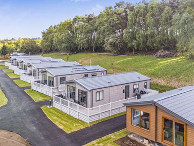 A row of lodges with a driveway at Cedar Lodge 3 Bedrooms with hot tub in Delamere