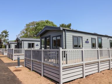 Exterior of cabins with wooden fences at Cedar Lodge 3 Bedrooms with hot tub Delamere