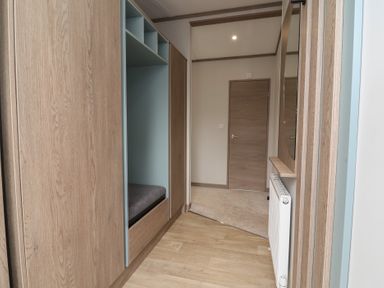 A hallway with a wardrobe and a bench at Cedar Lodge 3 Bedrooms with hot tub Delamere