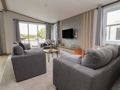 A living room with a sofa and television at Cedar Lodge 3 Bedrooms with hot tub in Delamere