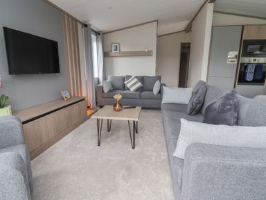 A living room with a sofa and coffee table at Cedar Lodge 3 Bedrooms with hot tub, Delamere