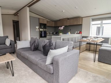A living room with a sofa and dining table at Cedar Lodge 3 Bedrooms with hot tub Delamere